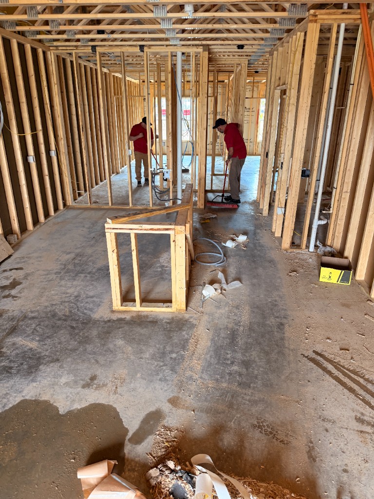 ND Cleaning crew performing rough cleaning at framed construction site
